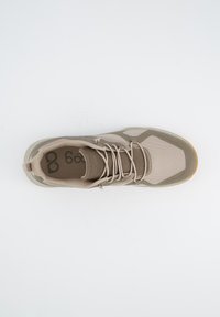 Tansfarbene und beige Sportschuhe mit einem strukturierten Mesh-Obermaterial, verstellbaren Schnürsenkeln und einer flexiblen Gummisohle mit einem kontrastierenden orangen Akzent.