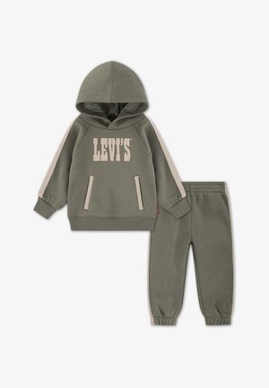 Kaki spalvos džemperis su "LEVI'S" logotipu ir derančios sportinės kelnės, turinčios kontrastingas šonines juosteles ir priekinės kišenes, tinkamos kasdieniam dėvėjimui.