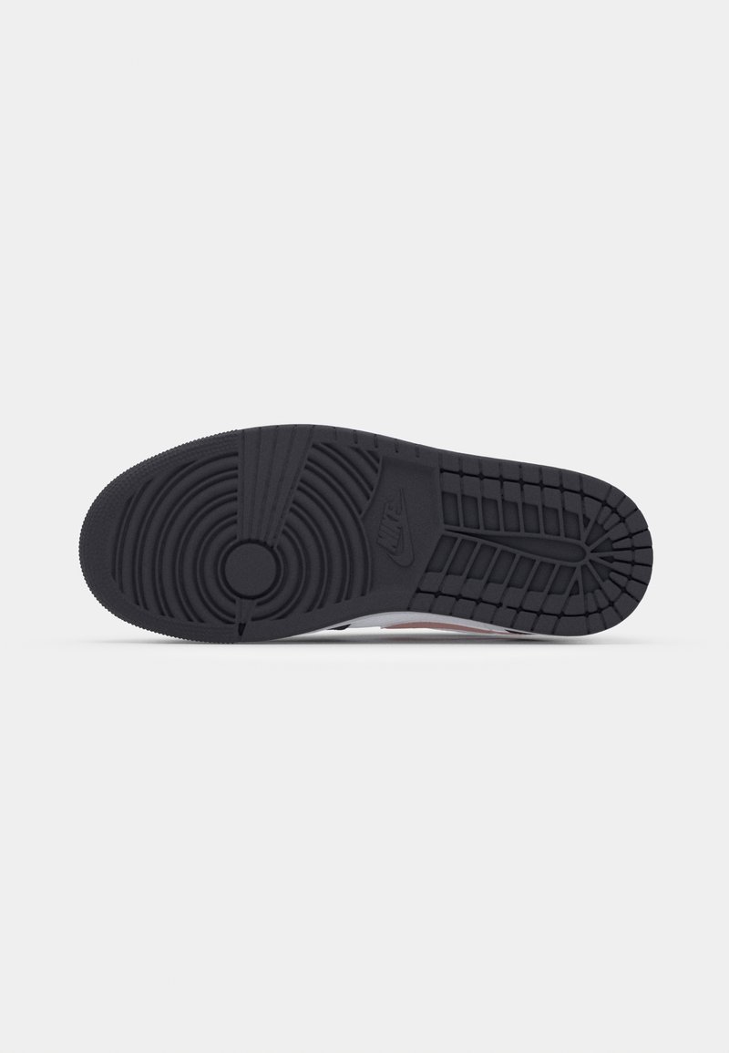 Suela de zapatilla Nike en goma negra, con un patrón de banda de rodadura circular, surcos y un destacado logo de Nike embossado cerca del talón.