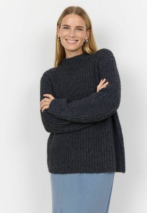 Dark gray ribbed knit sweater with a high neckline and dropped shoulders, paired with a light blue lower garment. Soft texture.