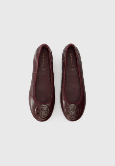 Burgundy leather ballet flats with round toe, tonal stitching, and embossed logo at the toe. Soft, smooth texture with no visible hardware.