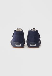 Sneakers high-top in suede blu navy con suola in gomma testurizzata, dotate di una fascia in velcro e un piccolo logo sul tallone.