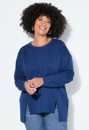 Tmavě modrý top s dlouhým rukávem, kulatým výstřihem, bočními rozparky a designem s texturovanými panely. Měkká látka s uvolněným střihem.