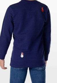 Granatowa bluza z małym czerwonym ornamentem w pobliżu lewego ramienia oraz białym bałwanem w czerwonym szaliku w pobliżu dolnego tyłu.