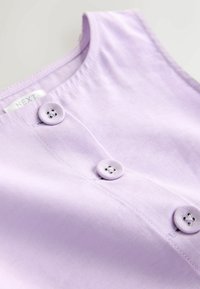 Lila ujjatlan felső, sima anyagból, két textillel borított, apró lyukakkal ellátott gombbal, varrott nyakkivágással és tiszta varrásokkal.