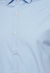 Lichtblauw overhemd met knoopsluiting, voorzien van een geometrisch patroon, zachte stof, puntkraag en knopen met een gladde afwerking.