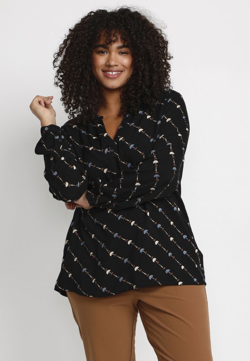 Black blouse featuring a patterned design with small floral accents in blue, white, and beige. Long sleeves with gathered cuffs.