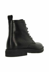 Bottines noires en cuir avec une finition lisse, un design à lacets et une semelle en caoutchouc plate. Dotées d'une languette à l'arrière pour un enfilage facile.