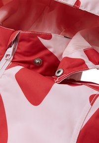 Rood en roze camouflage-patroon waterdichte jas met ritssluiting, metalen drukknoop en zachte voering. Zichtbare stiksels en textuur van de stof.