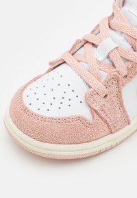 Le sneakers presentano un materiale in suede rosa con accenti in pelle bianca, dettagli texture, punta perforata e suola testurizzata.