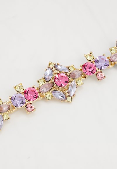 Armreif in Goldton mit einer Anordnung von pastellfarbenen Edelsteinen, darunter Rosa, Lila und Gelb, in unterschiedlichen Formen und Facetten.