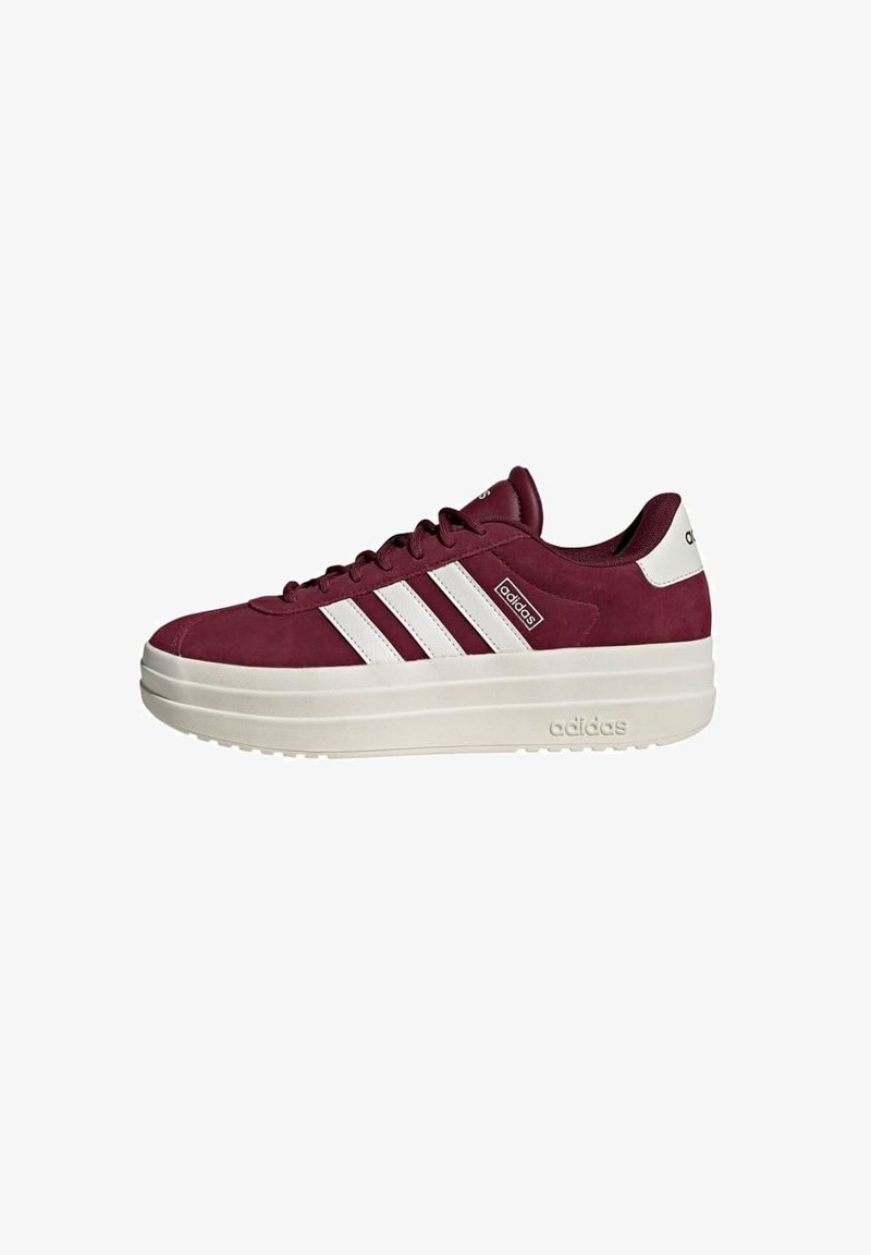 Sneakers in camoscio bordeaux con dettagli bianchi, caratterizzate da tre strisce, una suola platform bianca spessa e un logo sul retro.