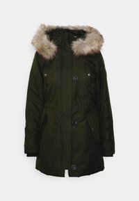 Parka verde oliva con capucha forrada de piel sintética, cierres de botones, bolsillos laterales y cintura elástica para un ajuste ajustable. Tejido liso y texturizado.