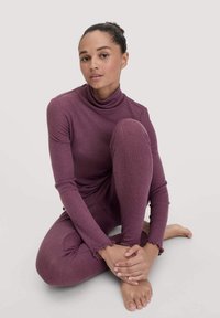 Langsleeve, coltrui en leggings in een diep paarse ribbelstof. Heeft geribbelde manchetten en een getailleerd ontwerp.