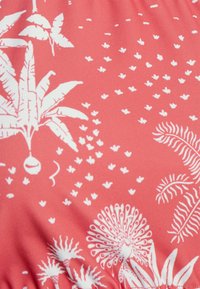 Tecido coral com padrões botânicos brancos, incluindo folhas, flores e pontos, com uma textura suave e acabamento macio.