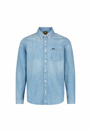 Camicia di denim azzurro chiaro con colletto abbottonato, maniche lunghe e una tasca sul petto. Presenta un'etichetta con marchio e bottoni bianchi.