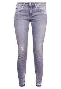 Vaqueros de denim ajustados, de color gris claro, con acabados desgastados, diseño de cinco bolsillos, cierre de botón y dobladillo deshilachado. Material suave y elástico.