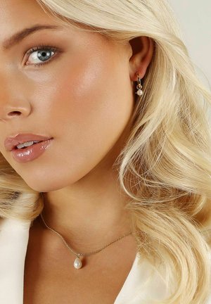 Guldörhängen med en hängande vit pärla, matchade med ett fint guldhalsband som har en droppformad pärla som hänge.