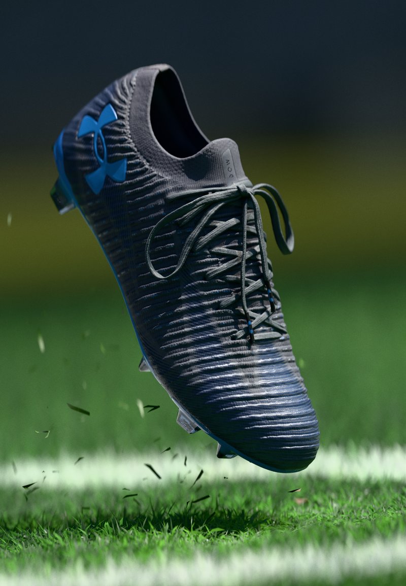 Scarpini da calcio neri con tomaia testurizzata, design con lacci e logo blu. Presentano tacchetti trasparenti per una presa efficace sulla superficie erbosa.