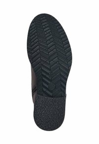 Suola di scarpa in gomma nera texturizzata con un motivo geometrico, dotata di un'area liscia sul tallone e un design con punta arrotondata.