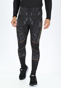 Schwarze Performance-Leggings mit geometrischem Muster, ausgestattet mit goldenen Akzenten und einem figurbetonten Design für sportliche Aktivitäten.