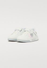 Hvide sneakers med en glat tekstur, som har en glitrende grå stjerneaccent og en pastelfarvet rosa detalje, velcrolukning og en struktureret sål.