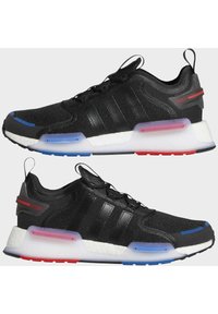 Black athletic shoes with mesh upper, three striped accents, a cushioned white midsole, and colorful heel details in blue and red.