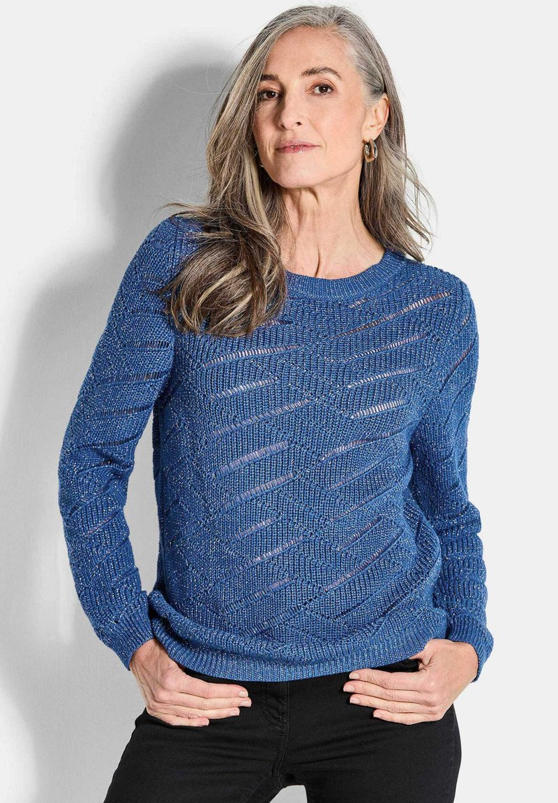 BlauerStrickpullover mit texturiertem Muster, der diagonale Ausschnitte und einen runden Hals hat. Lange Ärmel und eine lockere Passform.