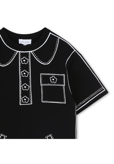 Μαύρο T-shirt με λευκή αντίθετη γιακά, λουρί κουμπιών και τσέπη με λεπτομέρεια λουλουδιών, κατασκευασμένο από απαλό βαμβακερό ύφασμα.