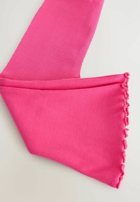 Maniche in tessuto a coste di un vivace rosa con bordo arricciato su una superficie chiara, piegate per mostrare la texture e i dettagli.