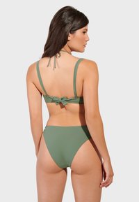 Maslinasto zeleni bikini set koji sadrži grudnjak s podesivim trakama i vezanjem na leđima, u kombinaciji s hlačicama visokog struka. Glatka tekstura, minimalistički dizajn.