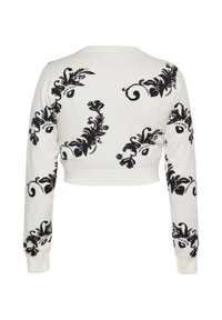 Maglione bianco tagliato con motivo floreale e a spirale neri. Maniche lunghe e orlo a coste. Tessuto liscio, design casual.