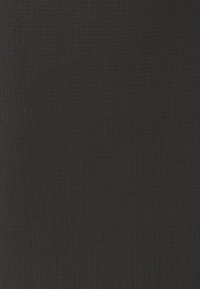 Svart tyg med en texturerad, något ribbad yta. Materialet verkar elastiskt och lätt, lämpligt för figurnära plagg.