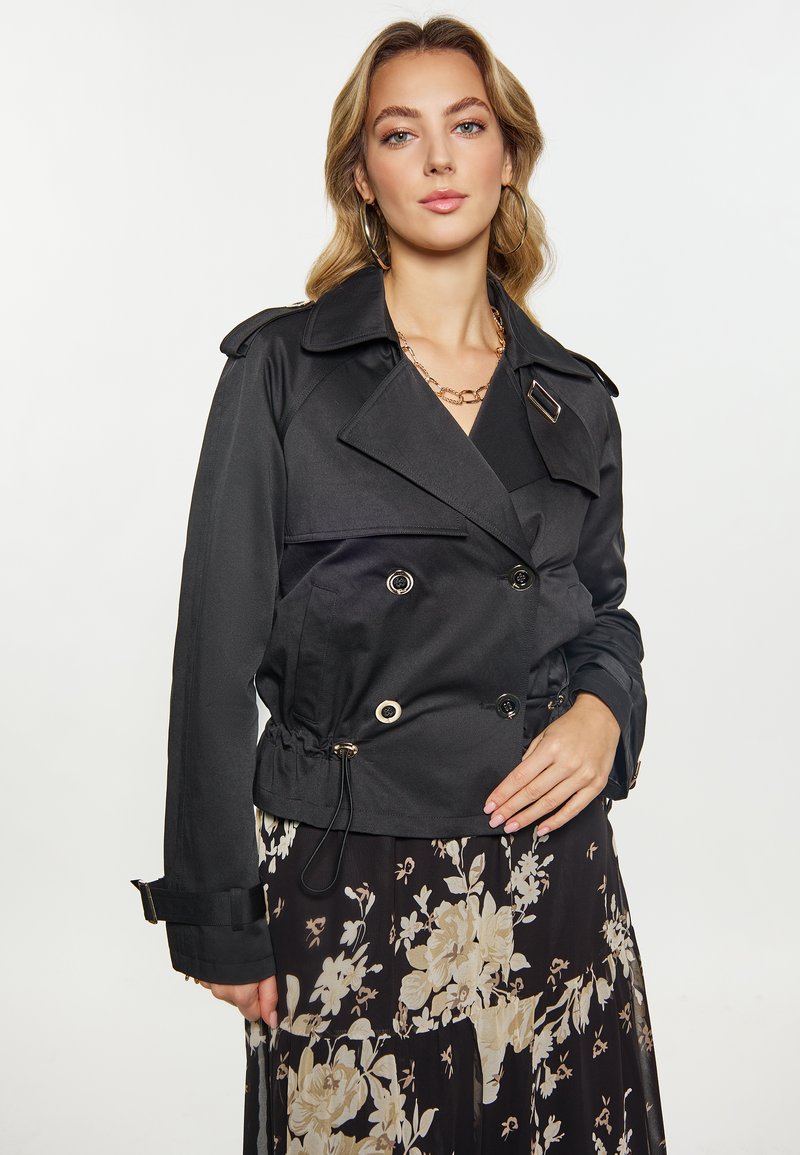 Sort tovejs jakke med peplum-design, der har store knapper, justerbar snørre i taljen og slagkrave.