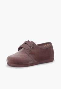 Scarpa slip-on in velluto di un colore mauve scuro con punta arrotondata. Presenta una parte superiore morbida, cuciture tono su tono e due laccetti decorativi con occhielli color oro.