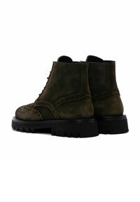 Botas de tobillo de ante verde oliva con un diseño de cordones, detalles con ondas y suelas de goma negra gruesa con un profundo dibujo.