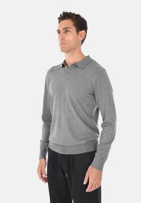 Maglione polo grigio a maniche lunghe realizzato in tessuto liscio, con colletto classico, polsini a coste e bordo fitted.