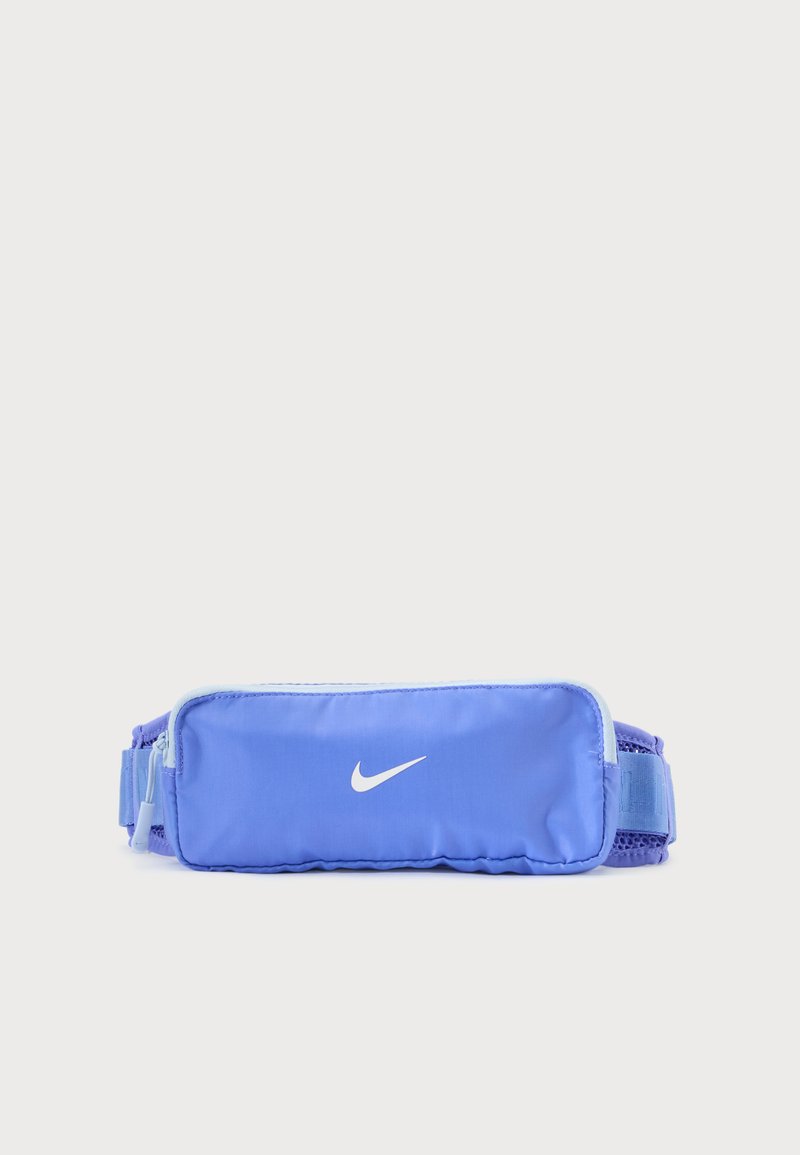 Pochette de taille Nike bleue avec logo blanc, poche principale zippée et sangle en mesh ajustable sur fond uni.