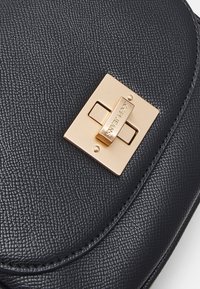 Borsa in pelle nera con texture, flap con chiusura a serratura rettangolare dorata incisa "JOOP! JEANS".
