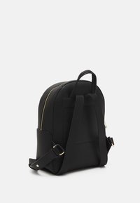 Mochila de cuero negro con textura de grava, dos correas ajustables, un asa superior y un detalle de cremallera dorada a lo largo del lateral.