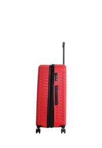 Red hardshell suitcase with a textured surface, black zipper, and retractable handle. Features four wheels for mobility.