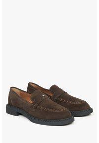 Brown suede loafers with a rounded toe, decorative stitching, metal logo accent, and a low black rubber sole.