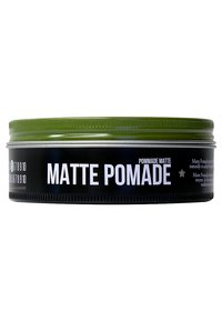 Groene metalen tin met matte pommade, voorzien van een zwart etiket met witte tekst. Het deksel heeft een gegroefde textuur en het ontwerp is eenvoudig en modern.