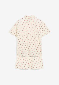 Top crema a maniche corte e pantaloni abbinati con un motivo di piccoli cuori rossi su tutta la superficie, sistemati piatti con la parte posteriore in vista.