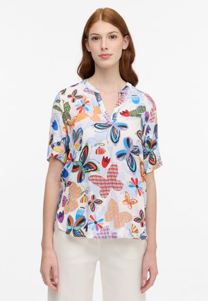 Kortærmet bluse med et blomstermotiv og sommerfugletrykt i livlige farver, med en diskret V-hals og let stof.