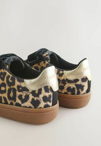 Sneaker med leopardmønster, sort lærredsupper, metalliske guldaccenter på hælen og tekstureret gummisål. Lav model.