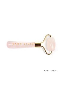 Rouleau facial en quartz rose avec une tête en pierre rose, des accents en métal doré et un manche gravé portant l'inscription "EASY LIVIN’."