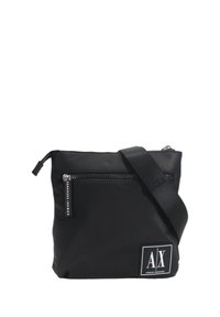 Borsa a tracolla in nylon nero con chiusura a zip, tasca frontale e tracolla regolabile. Presenta una toppa con logo bianco sulla parte anteriore.