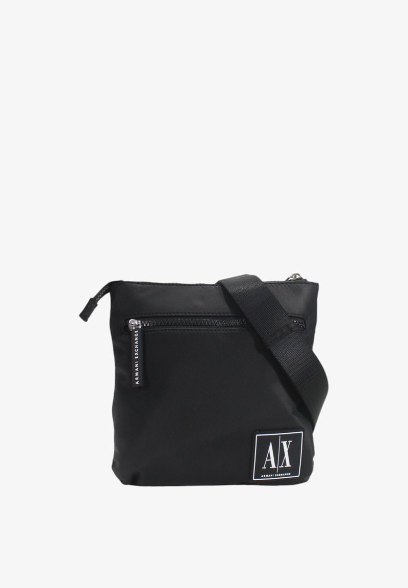 Sac bandoulière noir en nylon avec fermeture éclair, poche avant et bandoulière réglable. Dispose d'un patch logo blanc sur le devant.