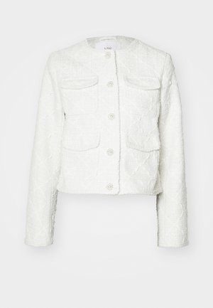 Jachetă albă scurtă, dintr-un material texturat. Are patru buzunare, închidere cu butoane și accente decorative, și un gât rotund.